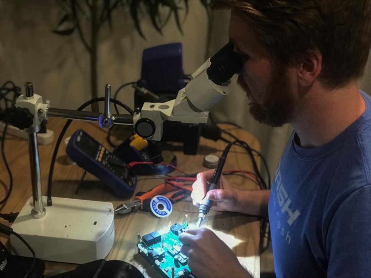 Frank Walsh reworking a circuit board under a stereo microscope